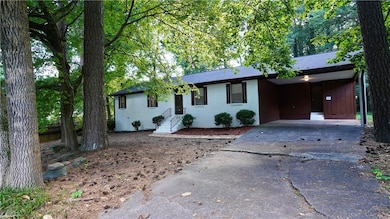 Single story home with asphalt driveway, brick siding, and an attached carport