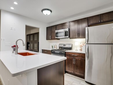 Kitchen with light countertops, dark brown cabine