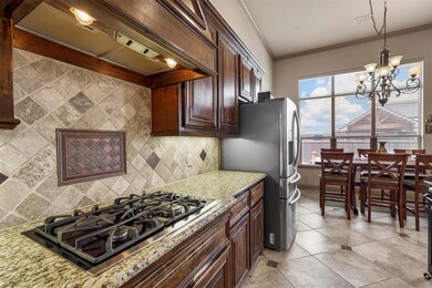 Kitchen featuring tasteful backsplash, light stone