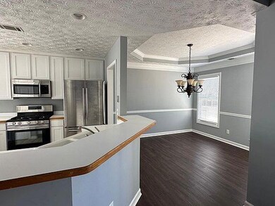 Traditional home featuring brick siding, an attached garage, a front lawn, concrete driveway, and roof with shingles