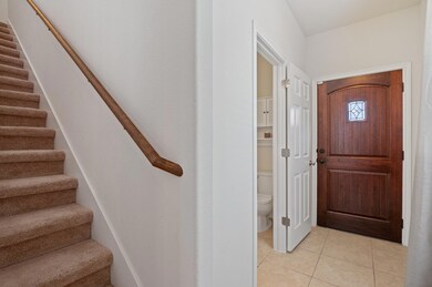 Entrance foyer with stairway and light tile patte