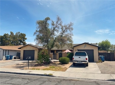 Ranch-style home featuring stucco siding, driveway, and a garage