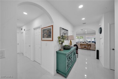 Corridor featuring arched walkways, baseboards, an