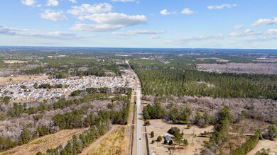 Aerial view of property and surrounding area with a forest