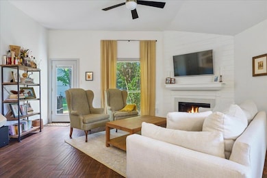 Living room featuring ceiling fan, dark wood fini