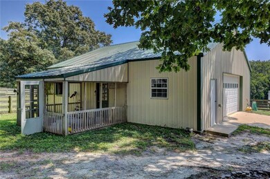 Large barn has a large garage door that opens to tons of space! Two stalls with a work area between, a tack room and plenty of space for your gator or ATV.