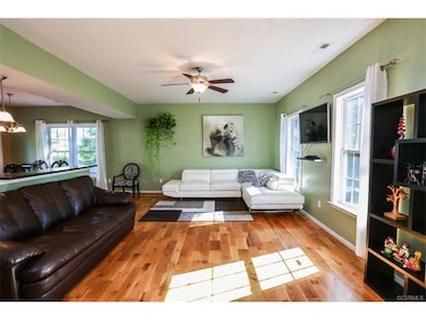 Living room w/ hardwood floors, ceiling fan, and t