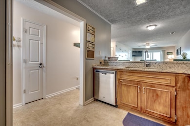 Kitchen with ceiling fan, light stone counters, si
