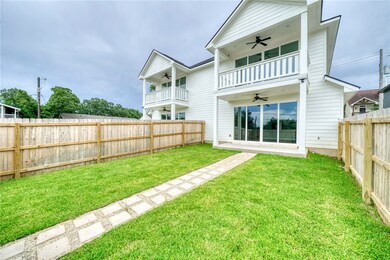 Back of house featuring a ceiling fan, a fenced ba