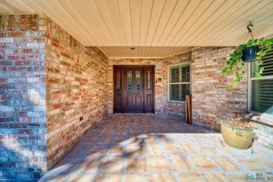 Property entrance with brick siding and a patio