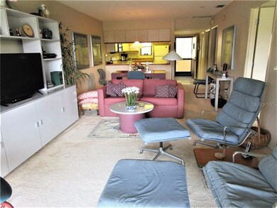 Living room has carpeted flooring & ceiling fan.