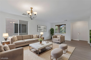 Living area with wood finished floors and a chandelier
