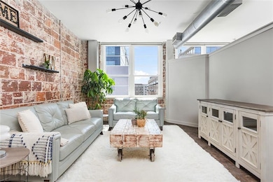 Living area with brick wall, a chandelier, and baseboards