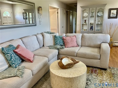 Living room with wood finished floors and a baseboard radiator