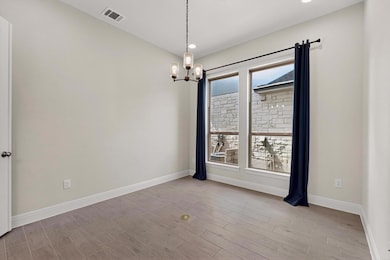 Unfurnished room with a chandelier, wood finished