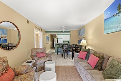 Living room with ceiling fan, light tile patterned floors, and crown molding