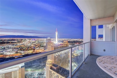 Balcony at dusk featuring a city view and a mountain view