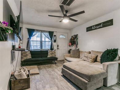 Living room with a ceiling fan, wood finished floors, and a textured ceiling
