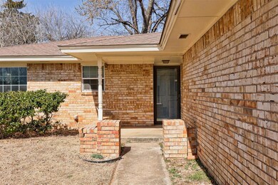 Doorway to property featuring brick siding and roo