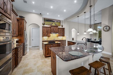 Kitchen with arched walkways, visible vents, appl