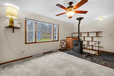 Living room with ceiling fan and a cozy pellet stove for those colder months.
