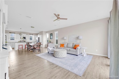 Living room with a ceiling fan and light wood finished floors
