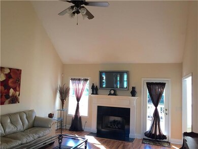 Attractive living room features new laminate flooring, vaulted ceiling, & fireplace with gas logs.