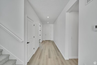 Hallway with recessed lighting, light wood finished floors, and baseboards