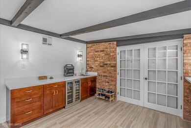 Bar with beamed ceiling, beverage cooler, a sink, 