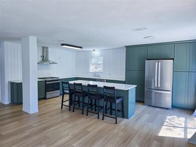Kitchen featuring wall chimney range hood, stainle