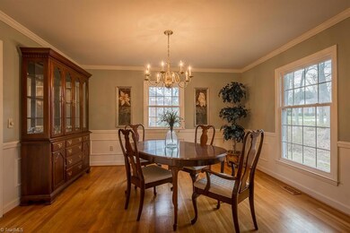 Dining room with crown, smooth ceilings, wainscoting, hardwoods.