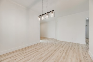 Unfurnished dining area featuring crown molding and light wood-type flooring