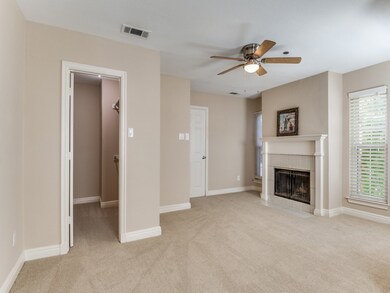 Unfurnished living room with light colored carpet, a ceiling fan, and a fireplace