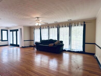 Living room featuring crown molding, ceiling fan, 