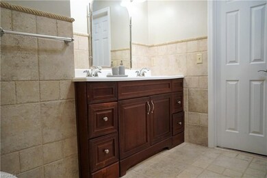 Tiled full bath with a double vanity.