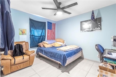 Bedroom featuring a ceiling fan and tile patterned floors