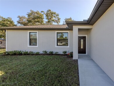 Doorway to property with stucco siding and a lawn