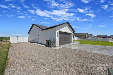 View of side of property featuring concrete driveway, a garage, and a gate