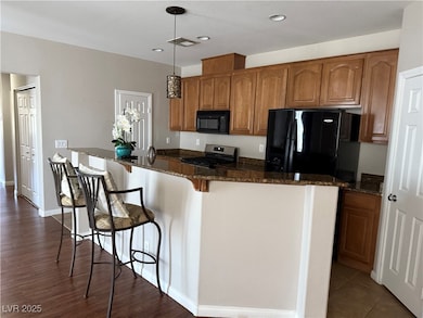 Kitchen with black appliances, brown cabinetry, de