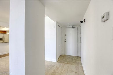 Hallway featuring light carpet and baseboards