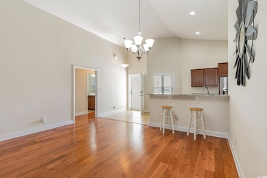 Kitchen featuring high vaulted ceiling, light wood