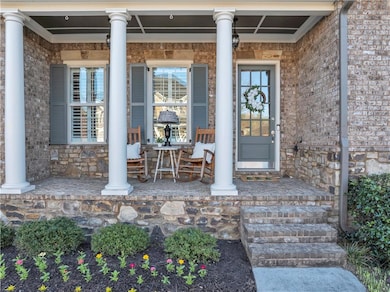 Property entrance featuring stone siding, brick si