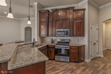 Kitchen featuring a sink, arched walkways, applian
