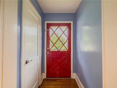 Doorway to outside featuring baseboards and dark wood-style flooring