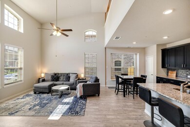 Living room with a healthy amount of sunlight, ceiling fan, and light hardwood / wood-style flooring