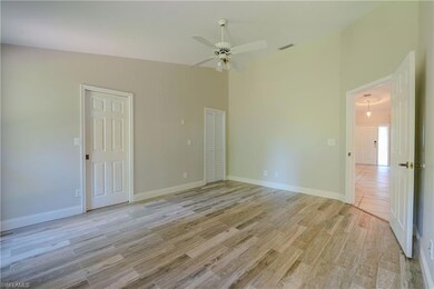 Spare room with light wood-type flooring, ceiling fan, and baseboards