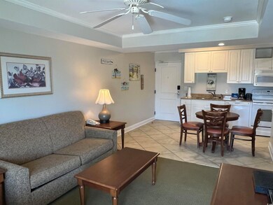 Living room featuring a tray ceiling, sink, light 