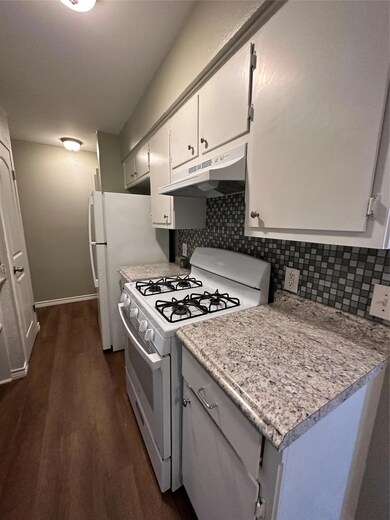 Kitchen with exhaust hood, decorative backsplash,