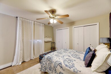 Tiled bedroom with two closets, baseboards, and c