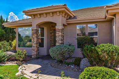 View of exterior entry with stucco siding, a tiled roof, and stone siding